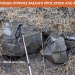 Hiking pole leaning on a stack of rocks amid dry grass; photo credit Φωτ: Naama Goren-Inbar in the lower left.