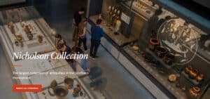 Overhead view of a museum gallery with glass display cases of ancient pottery; visitors examine artifacts near illuminated panels, with title 'Nicholson Collection' on screen.