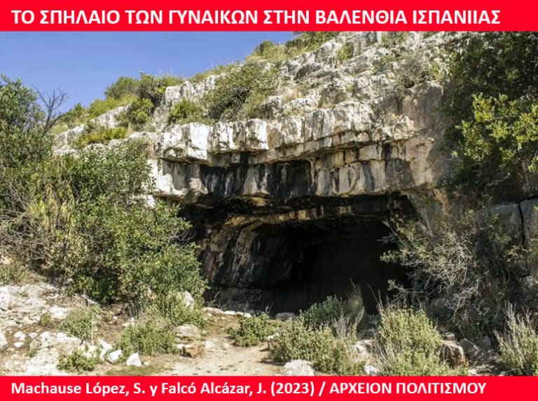 Rocky cave opening in a limestone cliff with sparse bushes, under a blue sky; a red banner with Greek text frames the top and bottom of the image, indicating a caption about a cave in Valencia, Spain.