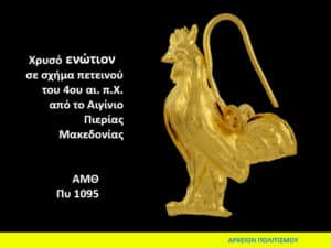 Gold rooster-shaped ornament, 4th century BCE, from Aegina Pieria, Macedonia; displayed on a black background with Greek inscription text nearby.