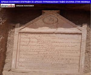Ancient stone grave marker with a triangular top and lines of Greek inscription carved on its face at an archaeological site