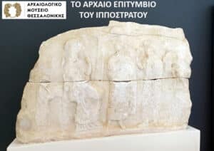 Ancient stone relief block with four standing figures, on display at the Archaeological Museum of Thessaloniki.