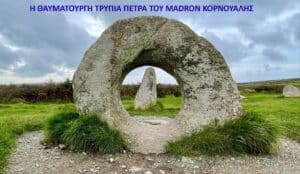 Circular stone arch with a tall central pillar, set on grassy ground under a cloudy sky in a rural landscape (prehistoric site).