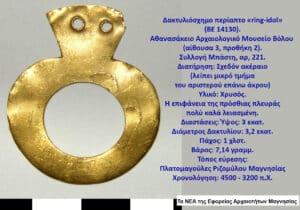 Gold ring-shaped pendant with two drill holes, shown beside Greek museum label detailing its origin and measurements.